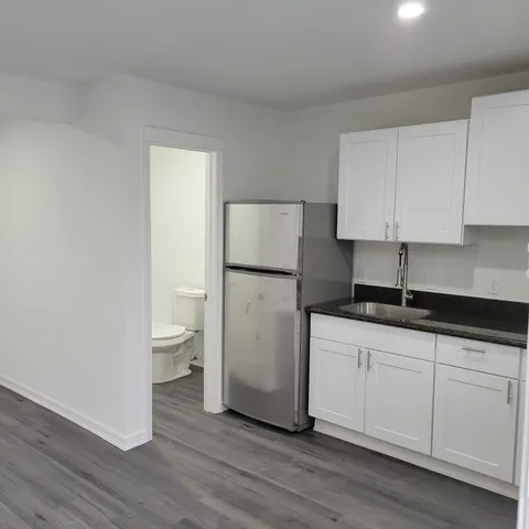 a kitchen with a sink a refrigerator and cabinets