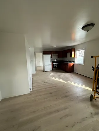 an empty room with furniture and a view of living room
