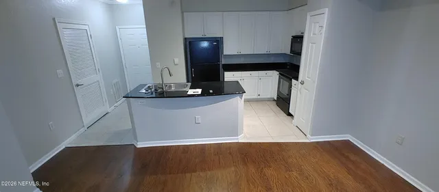 a view of a kitchen with cabinets and wooden floor