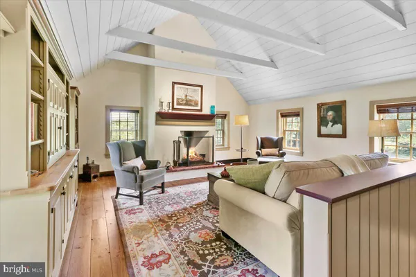 a living room with furniture a fireplace and a floor to ceiling window