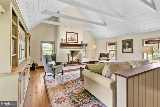 a living room with furniture a fireplace and a floor to ceiling window