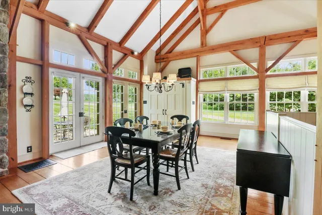 a view of a dining room with furniture next to ceiling windows and a rug