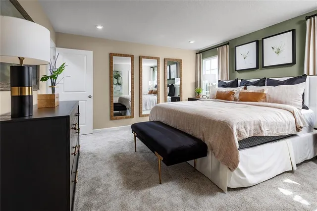 a bedroom with a large bed and painting on the wall