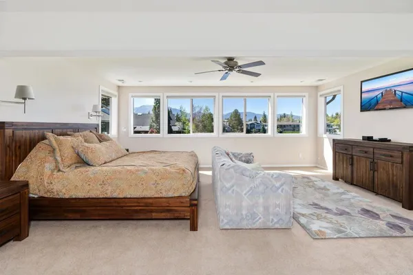 a view of an empty room with a window and a ceiling fan