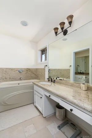 a bathroom with a granite countertop toilet a sink and a mirror