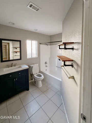 a spacious bathroom with a double vanity sink a toilet and a tub