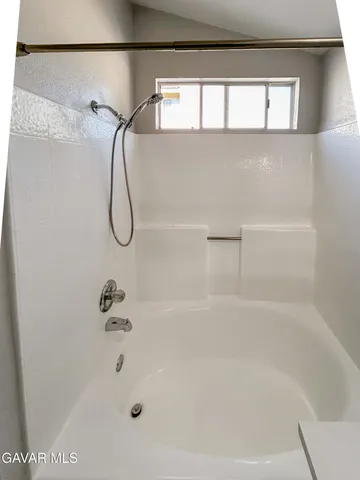 a bathroom with a bath tub with a shower