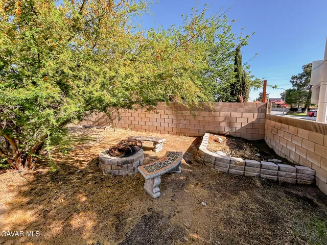 a view of a backyard with plants and outdoor seating