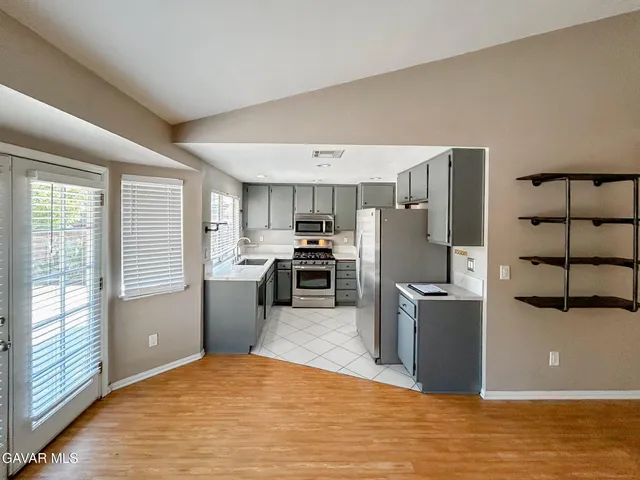 a kitchen with a refrigerator and a stove top oven