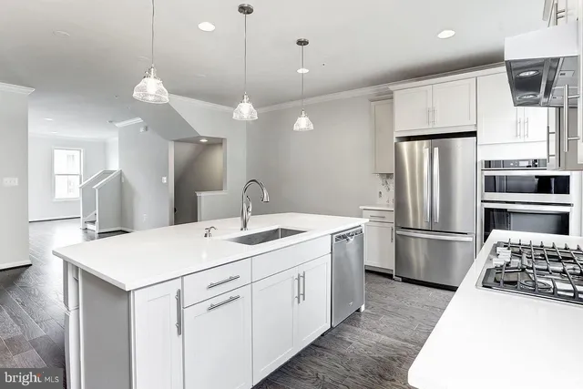 a kitchen with a sink stainless steel appliances and refrigerator