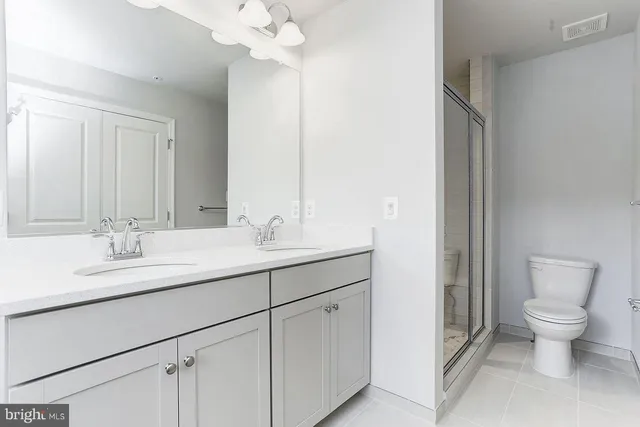 a bathroom with a granite countertop sink a toilet and a mirror