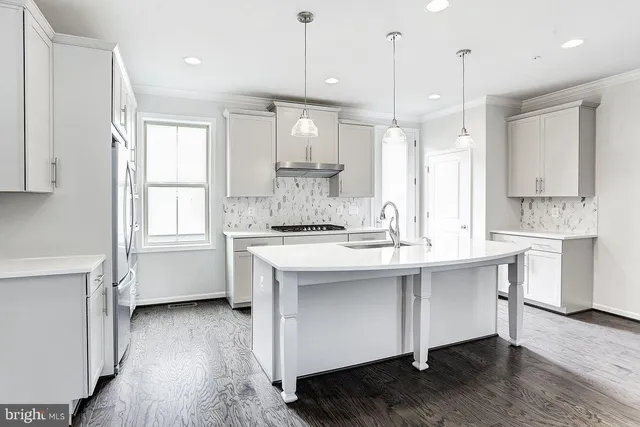 a kitchen with kitchen island white cabinets and sink