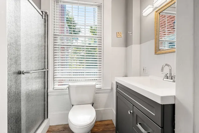 a large white kitchen with a large window and stainless steel appliances