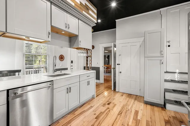 a kitchen with stainless steel appliances a refrigerator and wooden floor