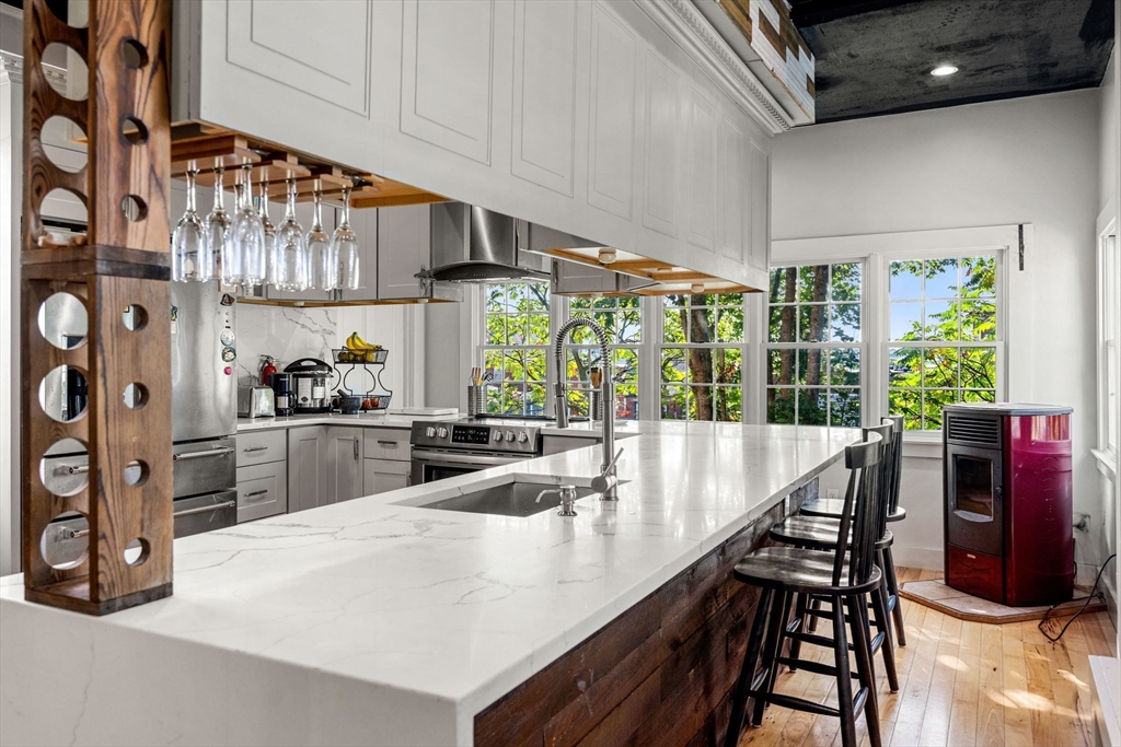 33 Middle Street Gloucester, MA 01930 - Photo 23 of 42 a kitchen with stainless steel appliances kitchen island granite countertop a table and chairs in it