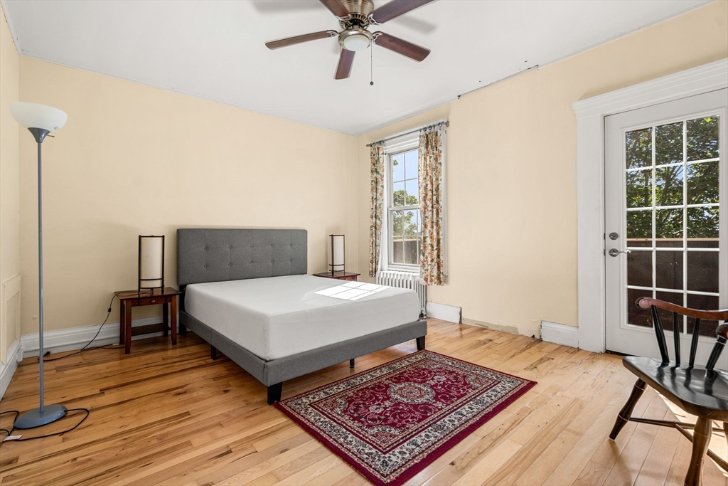 33 Middle Street Gloucester, MA 01930 - Photo 29 of 42 a bedroom with a bed a table and wooden floor