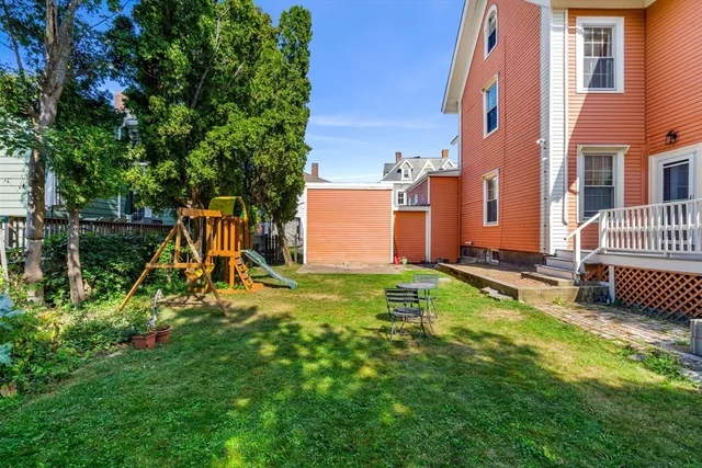 a view of backyard with a slide and a bench