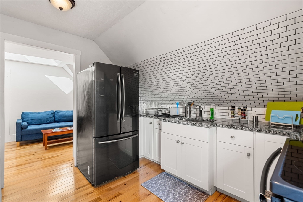 33 Middle Street Gloucester, MA 01930 - Photo 36 of 42 a kitchen with a sink wooden floor and stainless steel appliances