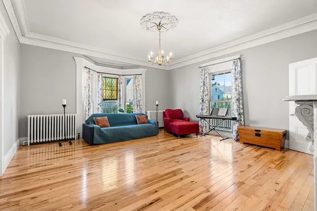 a living room with furniture a fireplace and a chandelier