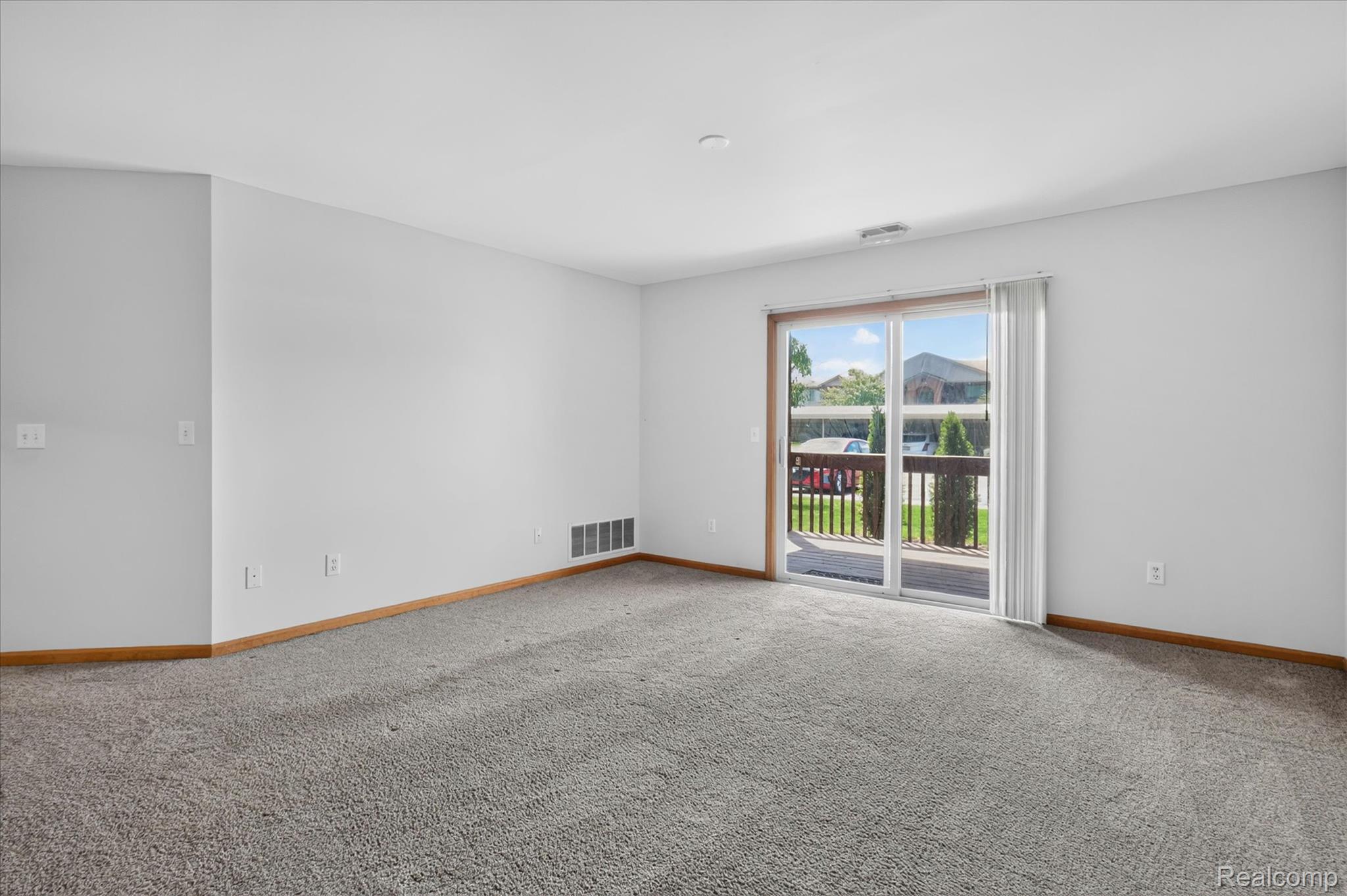 45720 Prairiegrass Court Belleville, MI 48111 - Photo 8 of 31 Spacious room featuring light gray wall paint, gray carpeting, and light wood-finish baseboards