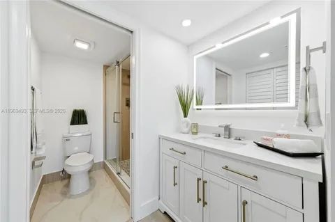 a bathroom with a granite countertop sink toilet and shower