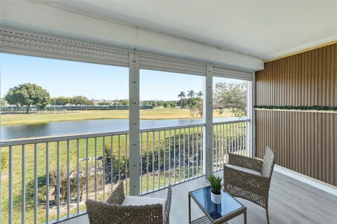 a view of a balcony with lake and outdoor seating