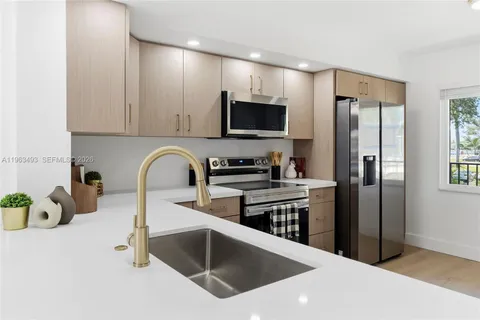 a kitchen with stainless steel appliances granite countertop a refrigerator sink and stove