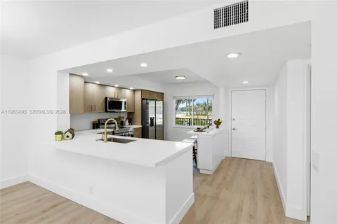 a view of a kitchen with a sink dishwasher stove and wooden cabinets
