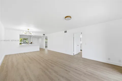 a view of a kitchen with wooden floor and a sink