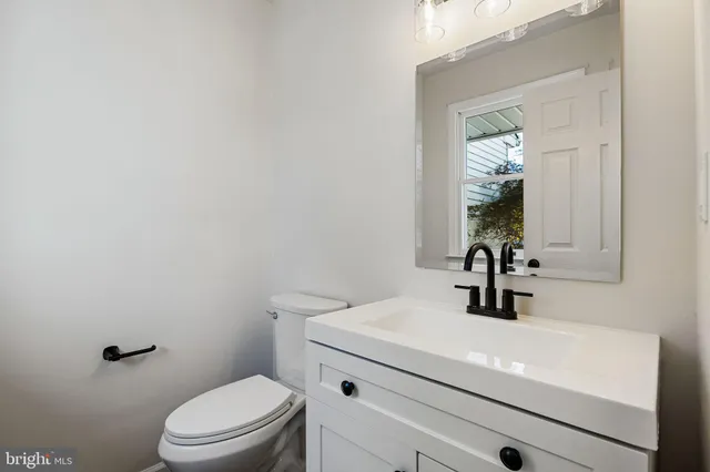 a view of a kitchen with white cabinets and wooden floor