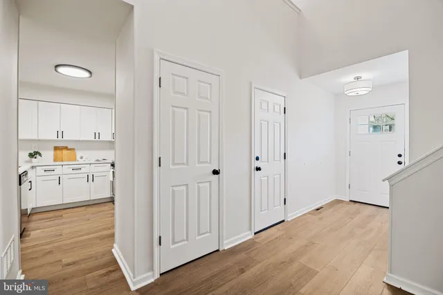 a kitchen with stainless steel appliances granite countertop a refrigerator a stove a sink dishwasher a dining table and chairs with wooden floor