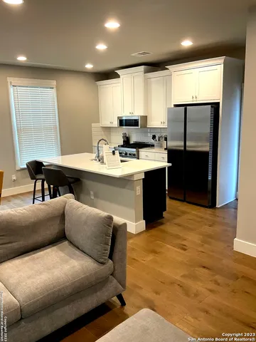 a kitchen with stainless steel appliances granite countertop a sink a stove a refrigerator a washer and dryer