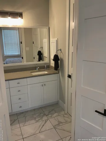 a spacious bathroom with a shower sink and mirror