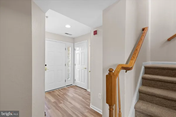a view of a hallway with wooden floor and staircase