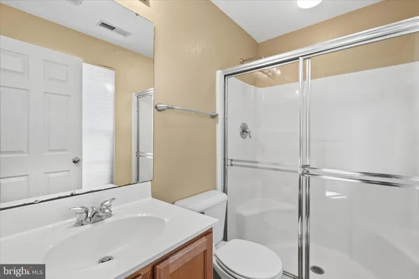 a bathroom with a sink vanity mirror and toilet