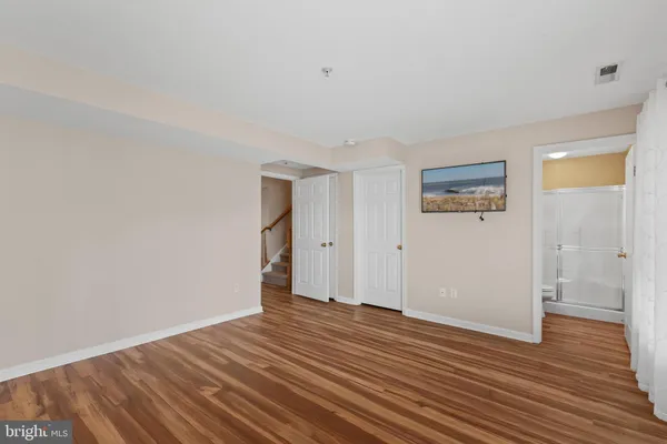 a view of an empty room with wooden floor