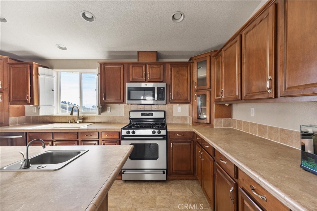 990 Mesa Valley Road Lebec, CA 93243 - Photo 11 of 38 a kitchen with kitchen island granite countertop a sink a counter top space appliances and cabinets
