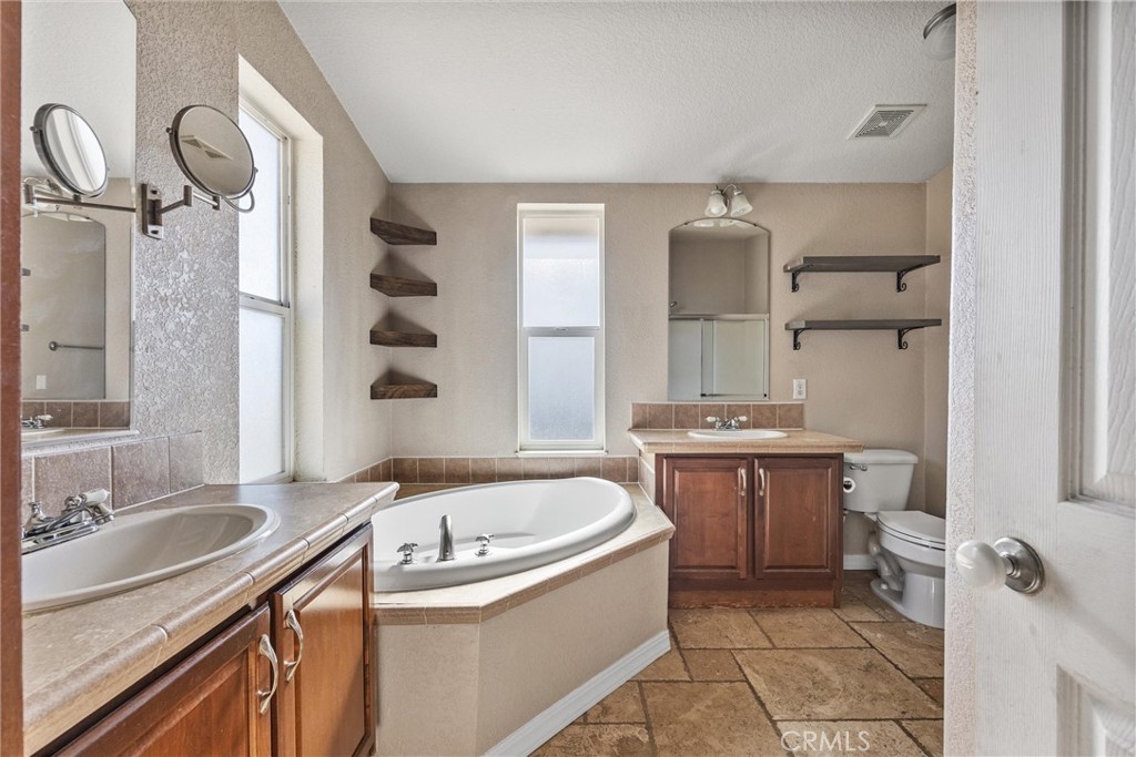 990 Mesa Valley Road Lebec, CA 93243 - Photo 16 of 38 a bathroom with a granite countertop sink mirror and a bathtub