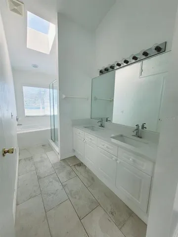 a spacious bathroom with a bathtub sink and mirror