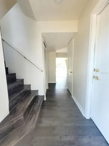 a view of a hallway with wooden floor and staircase