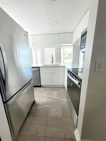 a kitchen with stainless steel appliances a refrigerator a sink a stove a microwave and cabinets