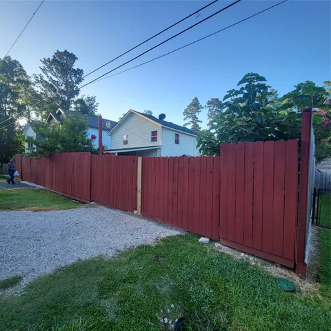 a view of backyard with wooden fence