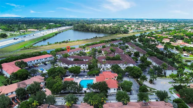 an aerial view of a city with lots of residential buildings ocean and mountain view in back