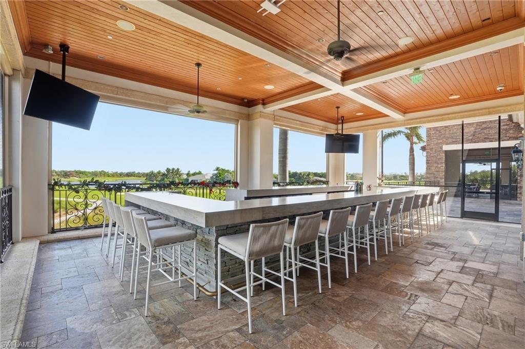 9578 Trevi Court, Unit 5124 Naples, FL 34113 - Photo 33 of 40 a dining space with furniture and a floor to ceiling window