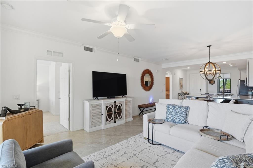9578 Trevi Court, Unit 5124 Naples, FL 34113 - Photo 5 of 40 a living room with furniture and a flat screen tv