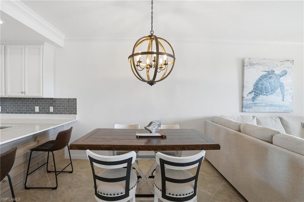 9578 Trevi Court, Unit 5124 Naples, FL 34113 - Photo 7 of 40 a view of a dining room with furniture and a chandelier