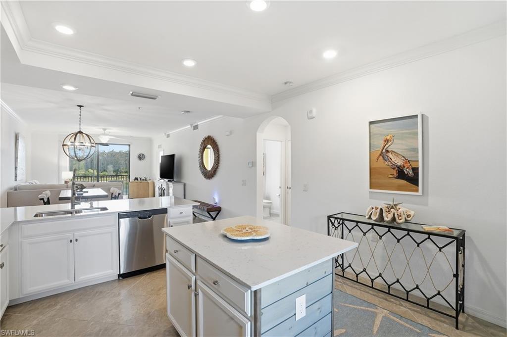 9578 Trevi Court, Unit 5124 Naples, FL 34113 - Photo 39 of 40 a kitchen with a sink a stove a refrigerator and a dining table with wooden floor