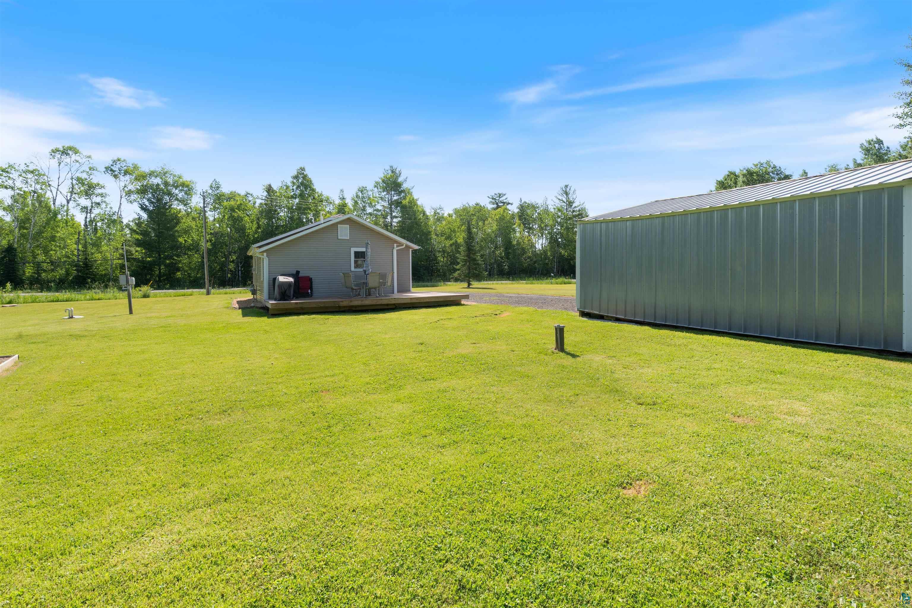 3835 South County Rd K South Range, WI 54874 - Photo 23 of 29 Expansive green lawn featuring a detached accessory building with siding, a metal roof, and a large side entrance