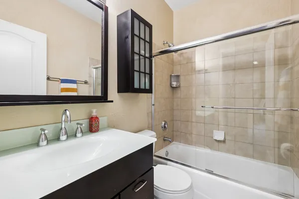 a bathroom with a sink a toilet a mirror and bathtub