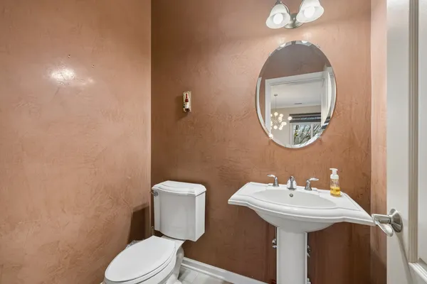 a bathroom with a toilet sink and mirror